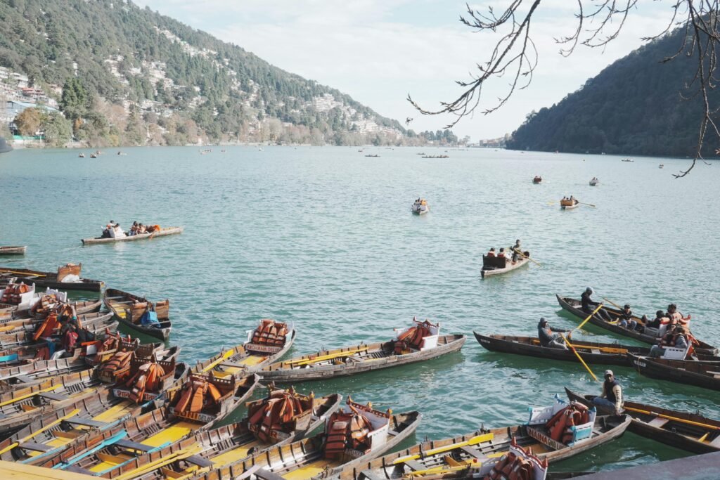 A picturesque scene of boats on Naini Lake, surrounded by lush hills in Nainital, a popular tourist destination.